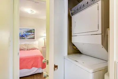 a small bedroom with a bed and a white refrigerator at Retro 3Br With Oceanview Patio In A Very Walkable Location By Beachview Rentals in Newport Beach