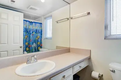 a white bathroom with a sink and a mirror at Retro 3Br With Oceanview Patio In A Very Walkable Location By Beachview Rentals in Newport Beach