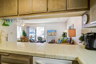 a kitchen with a counter top and a living room at Family Beach House Steps From Sand W Oceanview Patio By Beachview Rentals in Newport Beach