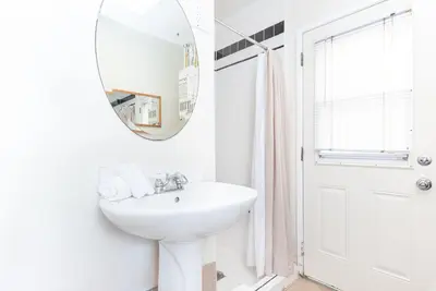 a white bathroom with a sink and a mirror at Pet-Friendly 3Br Retreat One House From The Sand By Beachview Rentals in Newport Beach