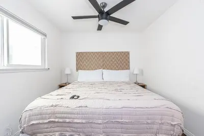 a bedroom with a large bed with a ceiling fan at Pet-Friendly 3Br Retreat One House From The Sand By Beachview Rentals in Newport Beach