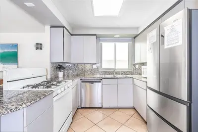 a white kitchen with white cabinets and appliances at Pet-Friendly 3Br Retreat One House From The Sand By Beachview Rentals in Newport Beach