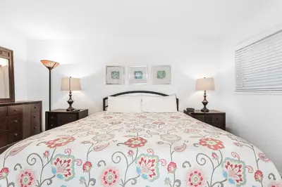 a bedroom with a bed with a floral bedspread at 3Br Home Steps To Beach And Boardwalk With Oceanview Patio By Beachview Rentals in Newport Beach