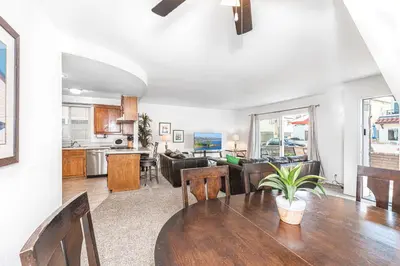 a kitchen and living room with a table and chairs at 3Br Home Steps To Beach And Boardwalk With Oceanview Patio By Beachview Rentals in Newport Beach