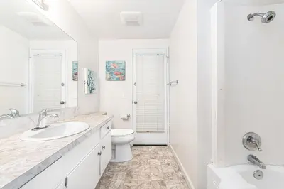 a white bathroom with a toilet and a sink at 3Br Home Steps To Beach And Boardwalk With Oceanview Patio By Beachview Rentals in Newport Beach