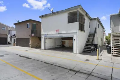 a white building with a garage on a street at 3Br Home Steps To Beach And Boardwalk With Oceanview Patio By Beachview Rentals in Newport Beach