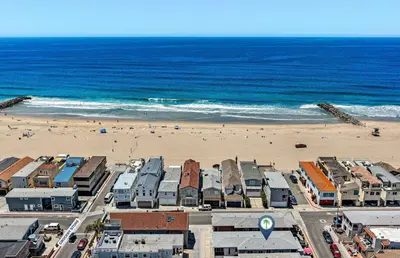 an aerial view of a beach with buildings and the ocean at 3Br Home Steps To Beach And Boardwalk With Oceanview Patio By Beachview Rentals in Newport Beach
