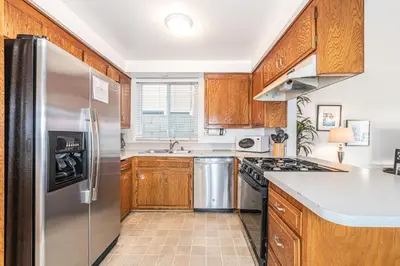 a kitchen with wooden cabinets and a stainless steel refrigerator at 3Br Home Steps To Beach And Boardwalk With Oceanview Patio By Beachview Rentals in Newport Beach