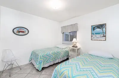 a bedroom with two beds and a chair at Retro 3Br Split-Level W Oceanview Patio Steps To Sand By Beachview Rentals in Newport Beach
