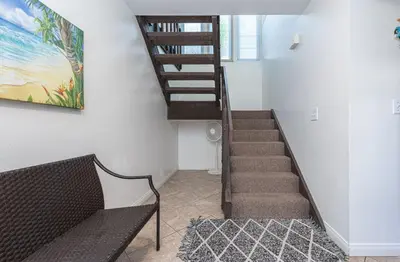 a staircase in a living room with a bench next to it at Retro 3Br Split-Level W Oceanview Patio Steps To Sand By Beachview Rentals in Newport Beach