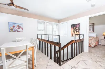a dining room with a table and a bed at Retro 3Br Split-Level W Oceanview Patio Steps To Sand By Beachview Rentals in Newport Beach