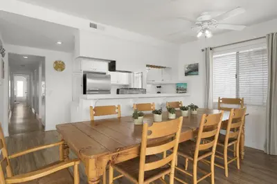a kitchen and dining room with a wooden table and chairs at Oceanview Corner Home W Rooftop Deck, One House From Beach By Beachview Rentals in Newport Beach