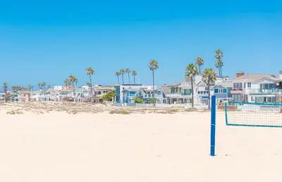 a volleyball net on the beach with houses at Oceanview Corner Home W Rooftop Deck, One House From Beach By Beachview Rentals in Newport Beach