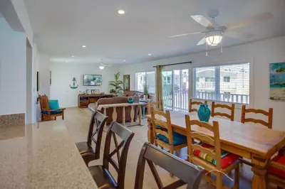 a dining room and living room with a table and chairs at 4Br Coastal Retreat Seconds From Popular 40Th Street Beach By Beachview Rentals in Newport Beach