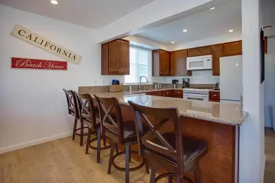 a kitchen with a island with bar stools at 4Br Coastal Retreat Seconds From Popular 40Th Street Beach By Beachview Rentals in Newport Beach