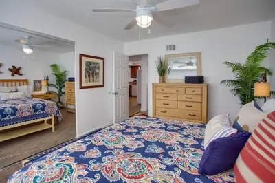 a bedroom with a large bed and a dresser at 6Br Duplex W Oceanview Patios, Steps To 40Th Street Beach By Beachview Rentals in Newport Beach