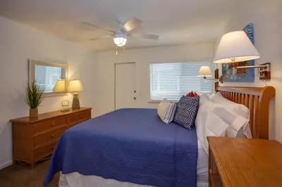 a bedroom with a blue bed and a ceiling fan at Ultimate Coastal Retreat Seconds From Sand W Oceanviews By Beachview Rentals in Newport Beach