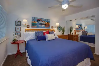 a bedroom with a blue bed and a ceiling fan at Ultimate Coastal Retreat Seconds From Sand W Oceanviews By Beachview Rentals in Newport Beach