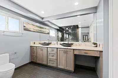 a bathroom with two sinks and a large mirror at Modern 4Br Vacation Home W Ocean Views And Rooftop Deck By Beachview Rentals in Newport Beach