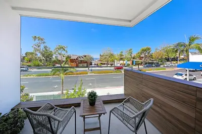 a balcony with a table and chairs and a view of a street at Luxury Stay Corona del Mar, Short Walk to Beach in Newport Beach