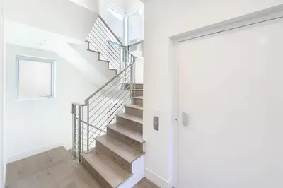 a staircase in a home with white walls and wooden floors at Luxury Stay Corona del Mar, Short Walk to Beach in Newport Beach