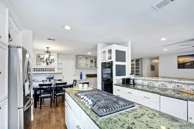 a kitchen with white cabinets and a dining room at Carlsbad Charm - 3BR Stunner in Carlsbad