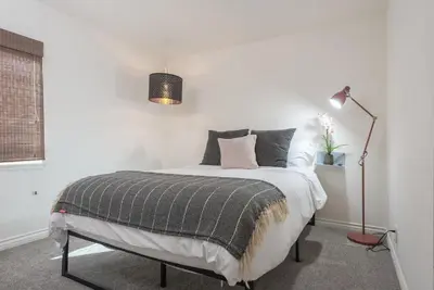 a white bedroom with a bed with a lamp at Family Retreat - Legoland & Beach in Oceanside