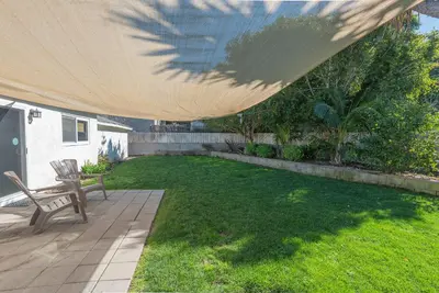 a patio with a bench under a large umbrella at Family Retreat - Legoland & Beach in Oceanside