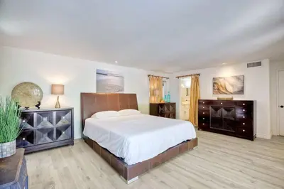a bedroom with a large bed with white sheets at Serene Coastal Home Sleeps 8 - 1 Mile from Beach in Encinitas
