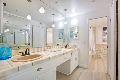 a bathroom with two sinks and two mirrors at Serene Coastal Home Sleeps 8 - 1 Mile from Beach in Encinitas