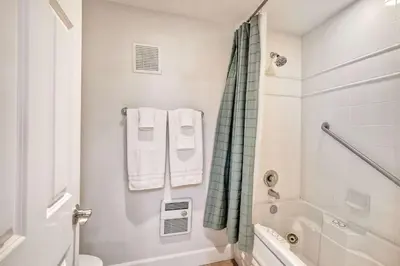 a white bathroom with a shower and a toilet at La Costa Gem - Condo for 3 in Carlsbad