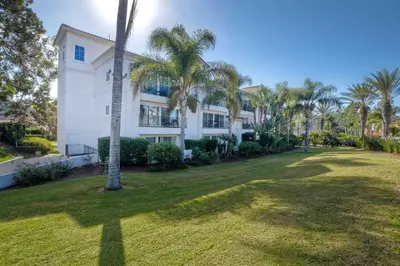 a palm tree in front of a white building at La Costa Gem - Condo for 3 in Carlsbad