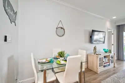 a dining room with a glass table and white chairs at La Costa Gem - Condo for 3 in Carlsbad