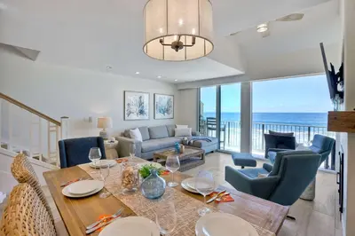 a dining room and living room with a view of the ocean at Seaside Sunset in Carlsbad