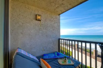 a balcony with a couch and a view of the ocean at Solana Sunset - Stunning Beachside Retreat for 4 in Solana Beach