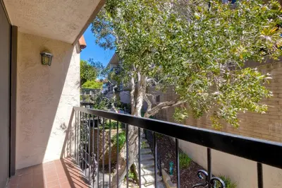 a balcony with a tree next to a building at Solana Sunset - Stunning Beachside Retreat for 4 in Solana Beach