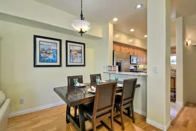 a dining room and kitchen with a table and chairs at South Pacific - Walk to Beach in Oceanside