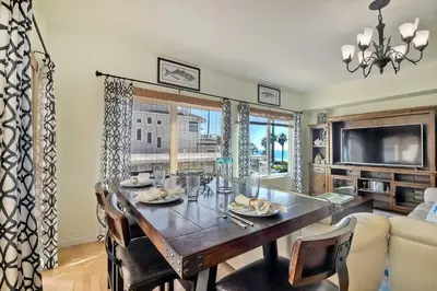 a dining room with a table and a couch at South Pacific - Walk to Beach in Oceanside