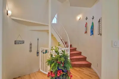 a hallway with a staircase with a flower arrangement at South Pacific - Walk to Beach in Oceanside