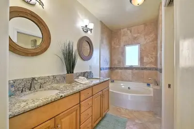a bathroom with a sink and a tub and a mirror at South Pacific - Walk to Beach in Oceanside