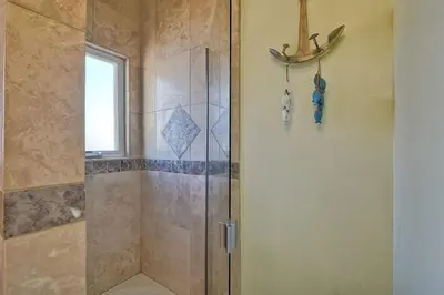 a shower with a glass door in a bathroom at South Pacific - Walk to Beach in Oceanside