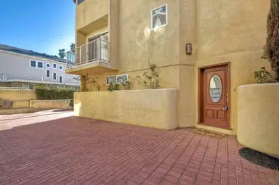 a building with a brown door and a balcony at South Pacific - Walk to Beach in Oceanside