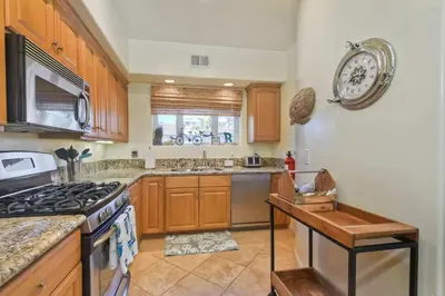 a kitchen with wooden cabinets and a stove top oven at South Pacific - Walk to Beach in Oceanside