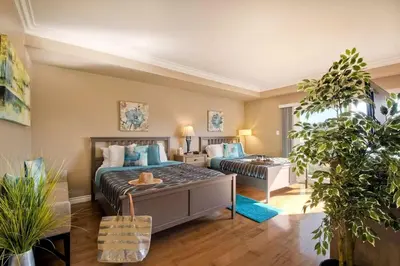 a bedroom with two beds and a desk in it at Southern Exposure with Private Balcony in Carlsbad