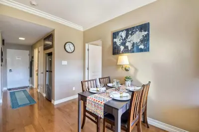 a dining room with a table and chairs and a clock at Southern Exposure with Private Balcony in Carlsbad