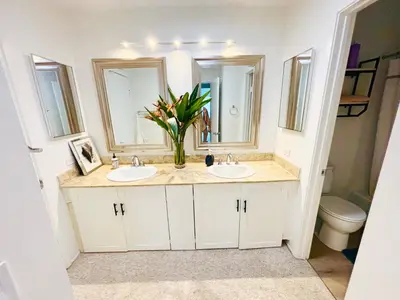 a bathroom with two sinks and a vase of flowers at Amazing House in La Jolla, CA in San Diego