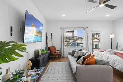 a living room with a couch and a bed at King Bed + Fire Pit | Top Floor w/ Epic Views in San Diego