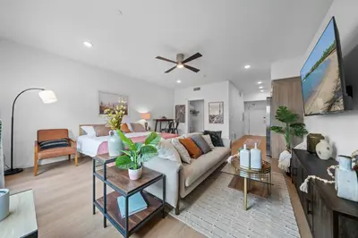 a living room with a couch and a ceiling fan at King Bed + Fire Pit | Top Floor w/ Epic Views in San Diego