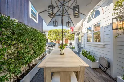 a wooden table on the front porch of a house at Balboa Island Gem with Patio & Beach Essentials in Newport Beach