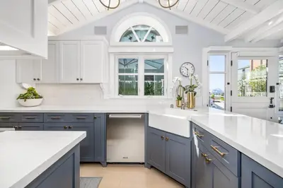 a kitchen with blue cabinets and a white counter top at Balboa Island Gem with Patio & Beach Essentials in Newport Beach